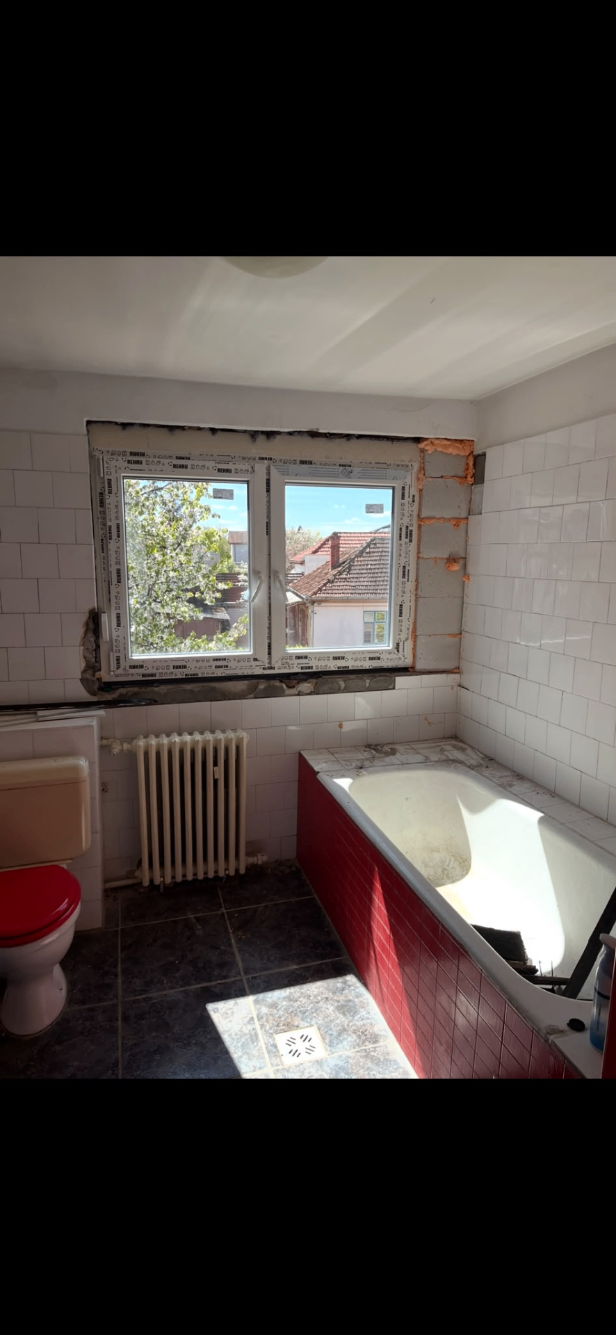 Baie înainte de renovare — cadă veche și faianță deteriorată