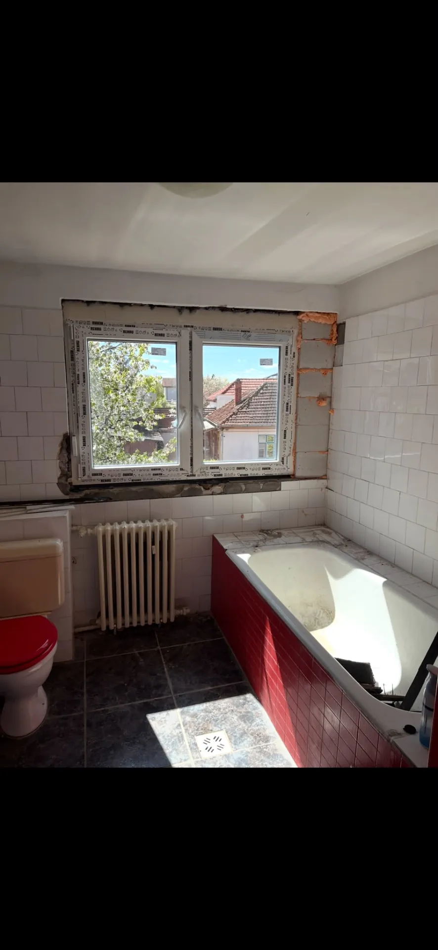 Baie înainte de renovare — cadă veche și faianță deteriorată