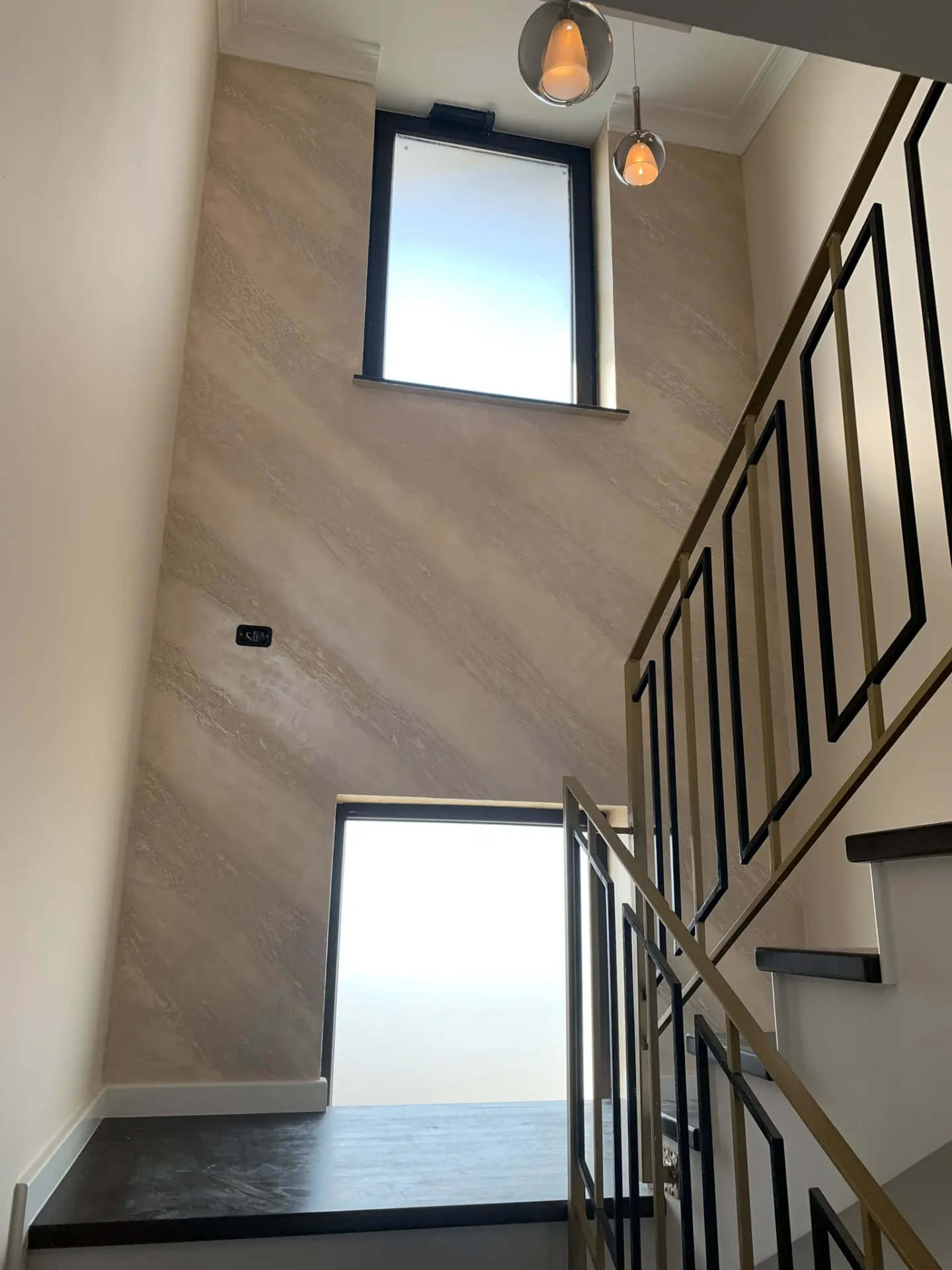 Palier superior cu ferestre înalte și balustradă din alamă și fier forjat