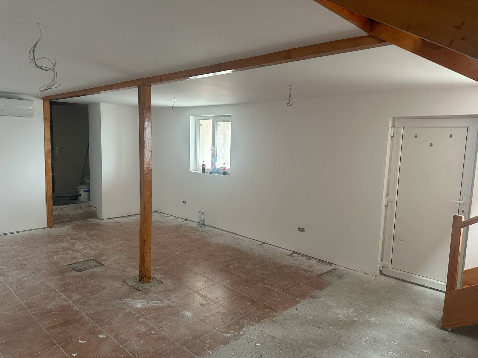 Interior amenajat la parter cu pereți finisați și grinzi aparente